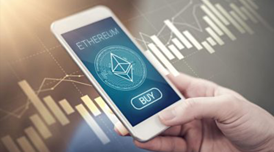 A hand holds a smartphone displaying an Ethereum logo and a "Buy" button. Background shows digital graphs, suggesting cryptocurrency trading.