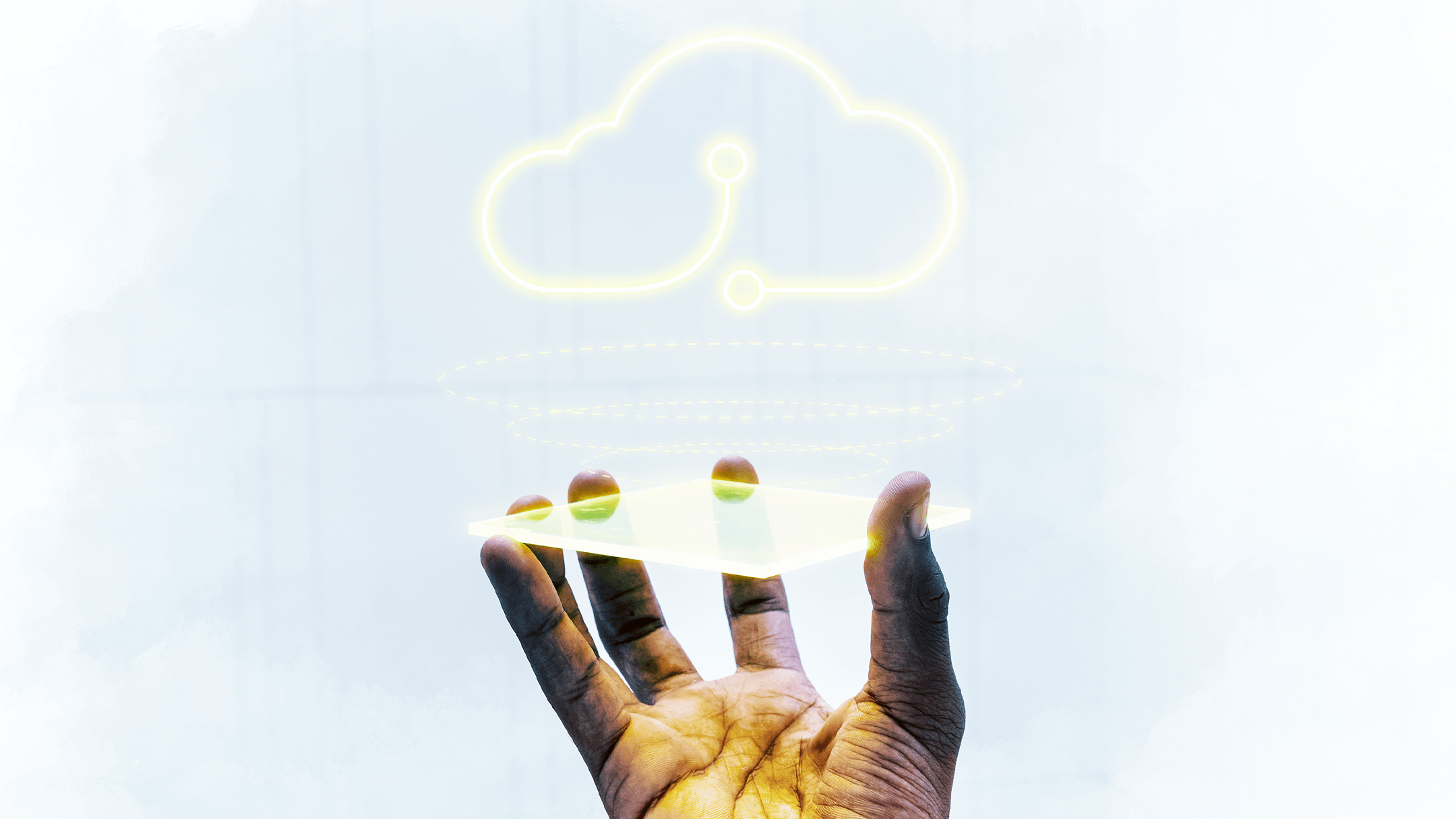 A hand holds an invisible tablet with a glowing digital cloud icon hovering above, symbolizing cloud computing. The background is softly blurred.