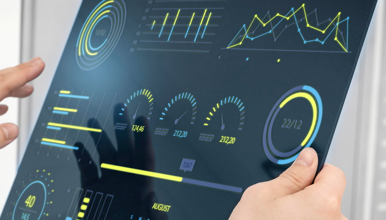 Person holding a digital screen displaying vibrant graphs and data visualizations in neon blue and yellow, conveying a sense of modern technology.