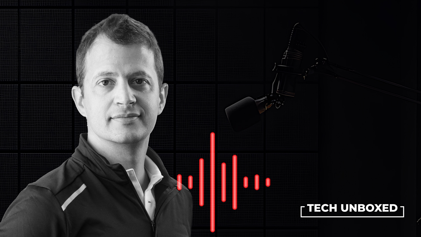 Black and white image of a man in a jacket, with a red sound wave pattern and microphone, titled "Tech Unboxed." The tone is modern and professional.