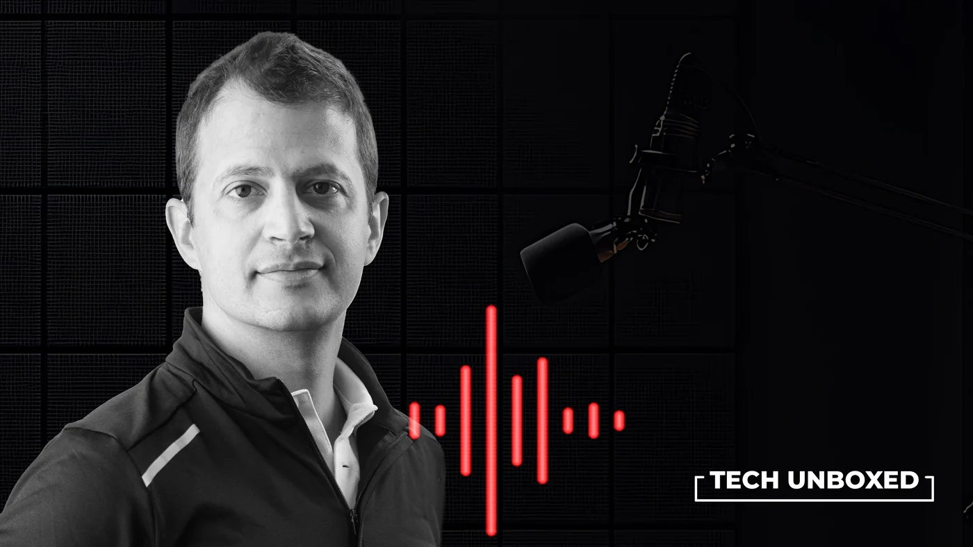 Black and white image of a man in a jacket, with a red sound wave pattern and microphone, titled "Tech Unboxed." The tone is modern and professional.