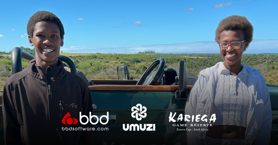 Two people smile warmly in front of an open-top vehicle at a game reserve. The background features lush greenery under a clear blue sky. Logos for BBD, Umuzi, and Kariega Game Reserve are at the bottom.