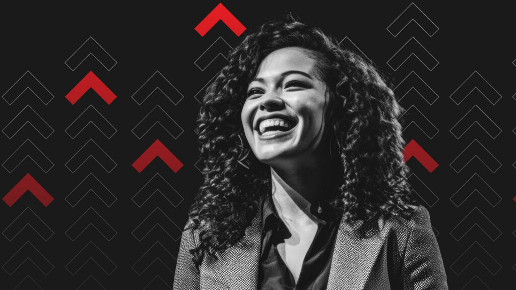 Smiling woman with curly hair in grayscale, wearing a suit against a black background with ascending red and white arrows. Energetic and uplifting mood.