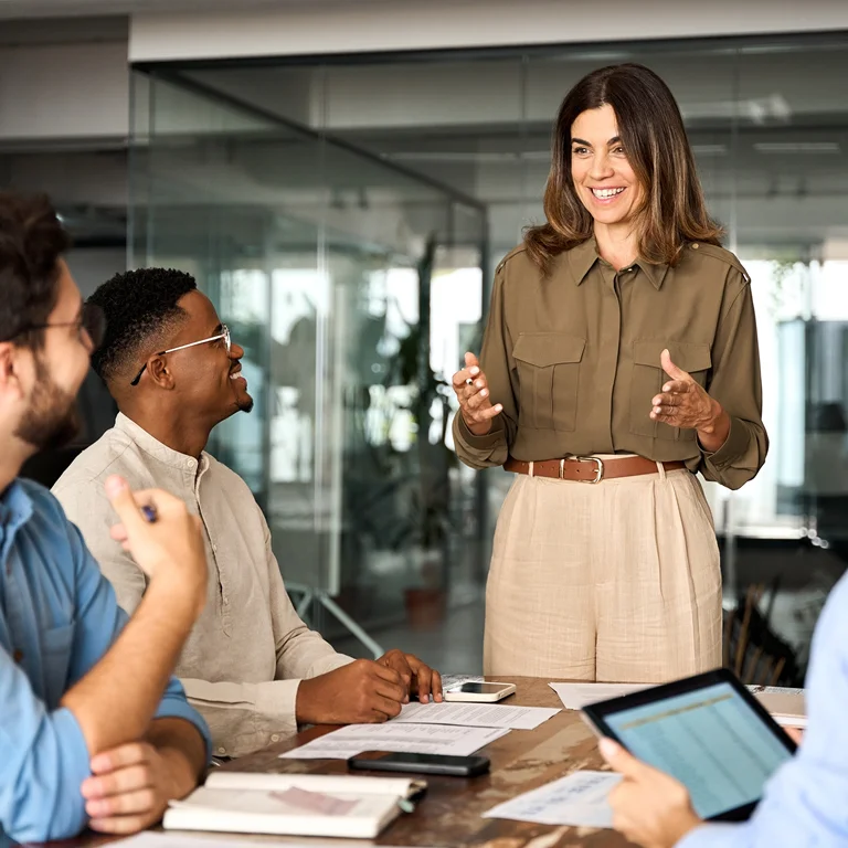 A confident woman leading a meeting with her team, symbolising managed IT services and leadership.